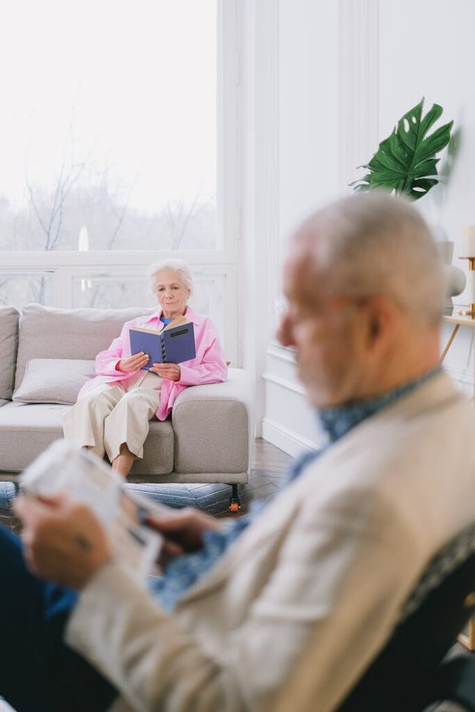 A senior couple enjoys reading in a cozy, well-lit living room with modern decor.